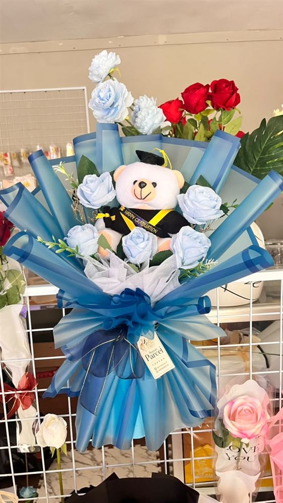 Buket wisuda biru dengan boneka beruang
