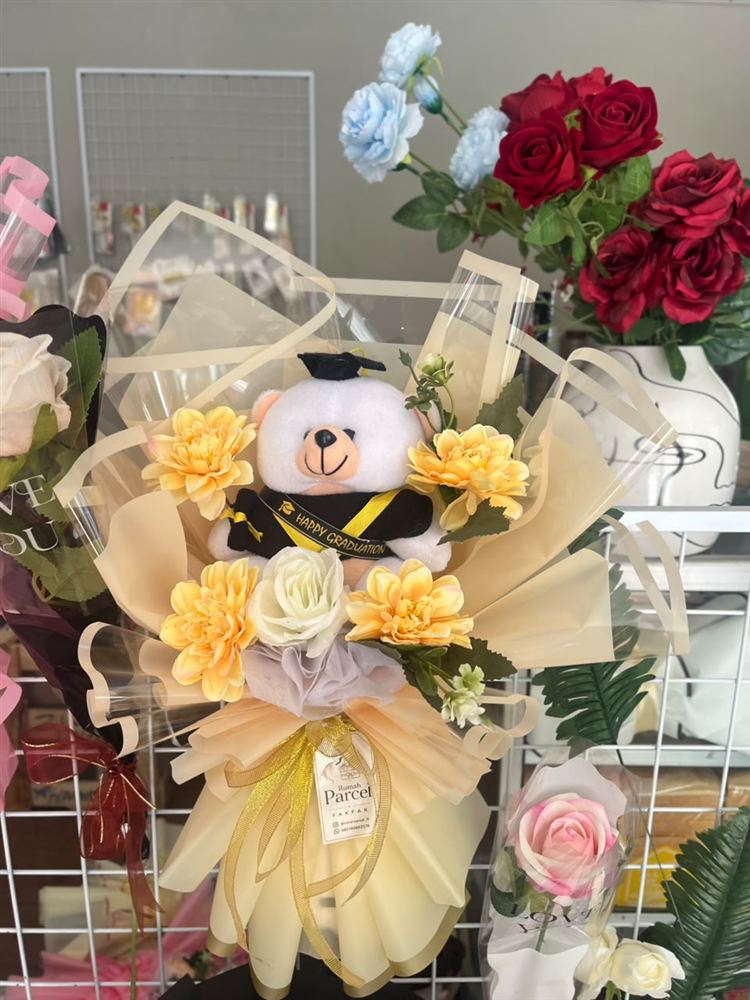 Buket wisuda dengan boneka beruang dan bunga kuning