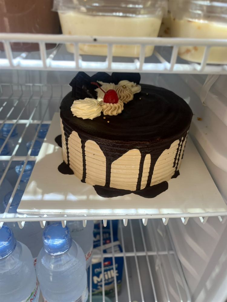 Kue cokelat dengan lelehan cokelat dan hiasan krim