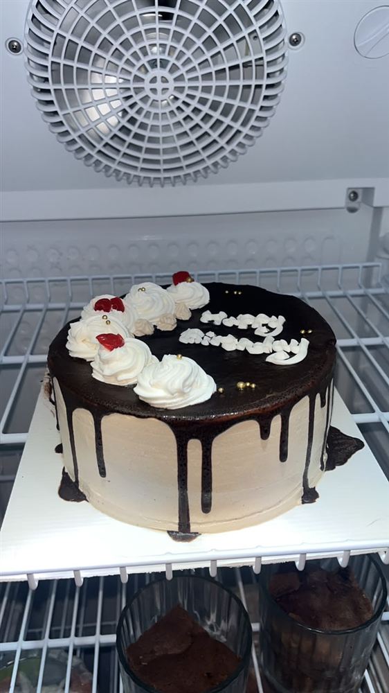 Kue cokelat dengan krim putih dan tulisan Happy Birthday